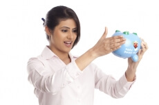 beautiful corporate woman looking at the piggy bank