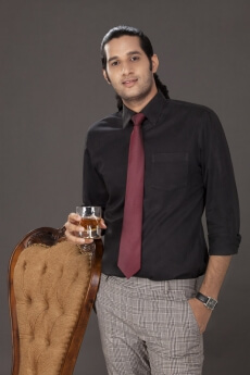 young man with one hand in pocket holding a drink 