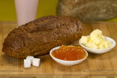 bread,butter,jam and sugar cubes on a wooden table