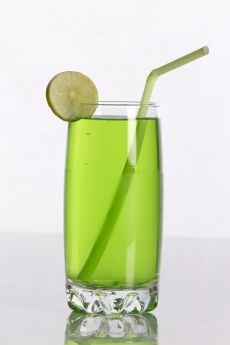 green coloured soda drink with straw and lemon