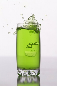 green coloured soft drink against a white background