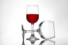 full and empty pair of red wine glasses