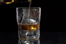 whiskey pouring from a bottle into a glass