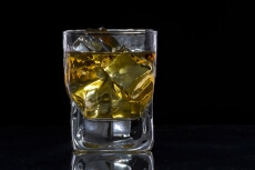 a glass of alcohol with ice cubes