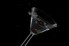 glass of drink stuffed with olive and cherry