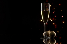 champagne glass with black background and decorative balls