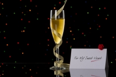 champagne glass with black background and note