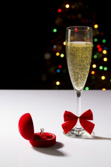 a flute glass full of champagne fizz with lights in the background