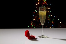 flute glass full of champagne with wedding ring beside