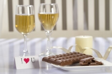 table decorated with chocolates,champagne,love note and scented candle