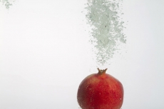 pomegranate dunked into water showing air bubbles