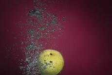 fresh pear falling into clean water