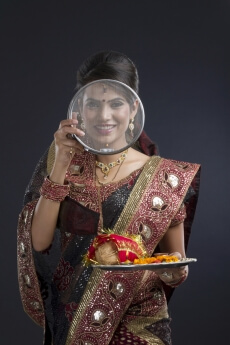 Indian woman looking through the strainer on karva chauth