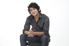 a guy in formals sitting on a chair 