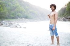 a man posing shirtless while carrying his shirt