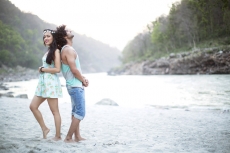 young couple romancing by the riverside 