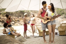  teenage boy making a girl learn to play guitar