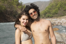 teenage couple posing for the camera at the beach