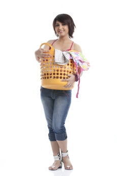 beautiful housewife holding a basket of clothes