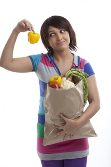 young housewife looking at capsicum