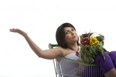 woman waving with a package of vegetables