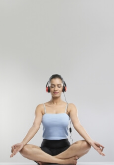 young girl performing meditation with headphone on 