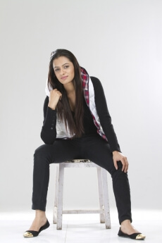 portrait of a smiling lady sitting on a stool in a hoodie