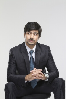 young male executive sitting on a chair and posing 