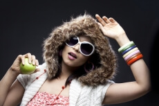 model in winter hoody holding a green apple