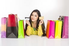 girl lying on the floor with shopping bags holding credit cards
