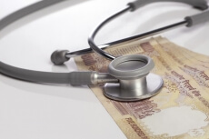 close up shot of stethoscope and cash 