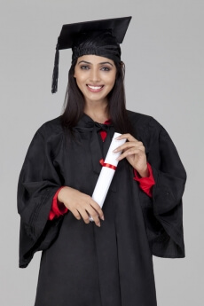 girl posing in graduation gown with degree in hand