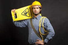 man dressed as engineer carrying caution board 