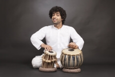 man playing tabla while looking at the camera 
