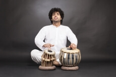 man playing tabla with grey background