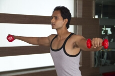 boy doing cardio at the gym with dumbbells