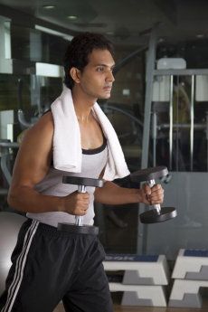 young male sweating hard at the gym while doing a workout