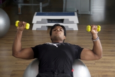 guy with good physique traing on a fitness ball
