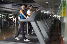 side view of three people walking on the treadmill