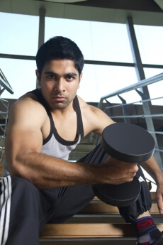 guy holding a dumble with a strong look on his face