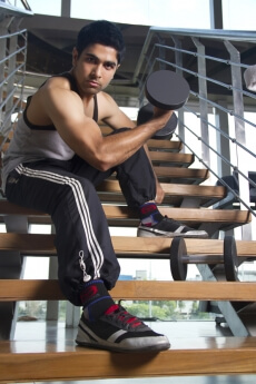 boy sitting at the stairs holding dumbles