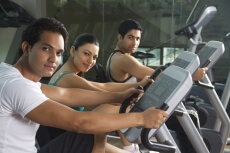men and woman cycling at the gym