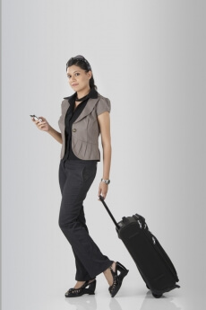 business woman travelling with a suitcase and a phone 