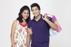 couple posing with shopping bags while looking at camera