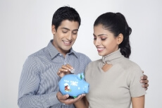 woman dropping a coin in the piggy bank