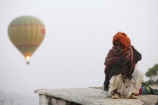 balloons flying over an idle old man