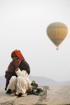 balloons flying over an idle old man