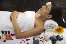 girl lying with hot stone on forehead 