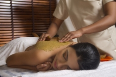 therapist applying ayurvedic  pack with both hands 