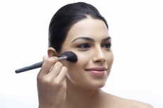 close-up of woman applying blush